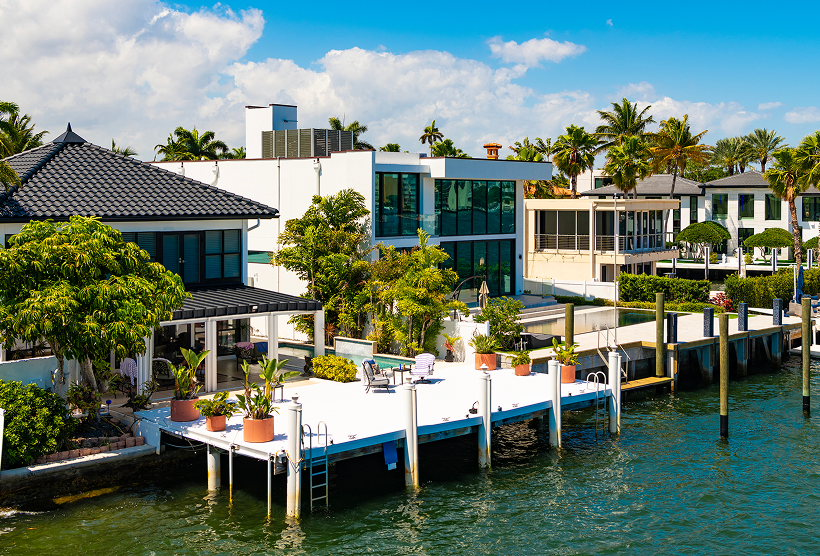 Waterfront homes with docks and palm trees